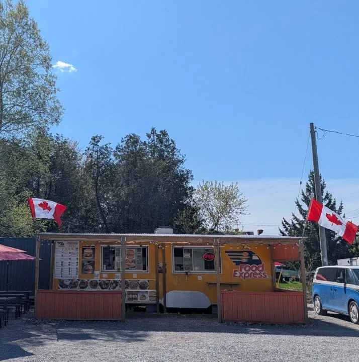 The yellow Food Express truck and its patio, with Canadian flags flying